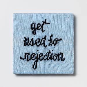Kate Just, Rule #3: Get Used to Rejection, 2024, hand knitted acrylic yarn, canvas, and timber, 26 x 26 cm