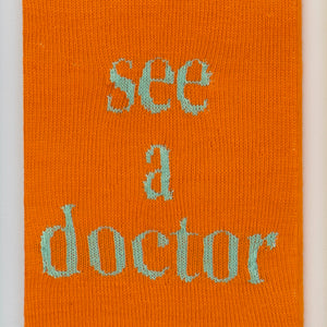 Kate Just, See a Doctor, 2023, from Self Care Action Series, hand knitted acrylic yarn, canvas, and timber, 55 x 40 cm