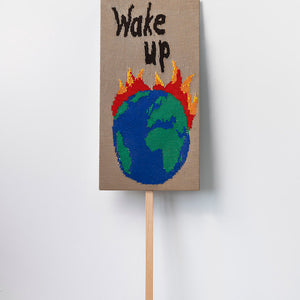 Kate Just, Wake Up, 2022, knitted wool as placard with plywood stand, 98 x 50 cm