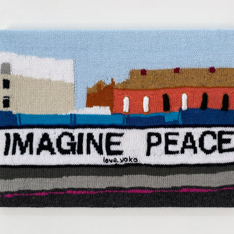 Kate Just, A Sign of the Times: A knitted translation of Yoko Ono, Imagine Peace billboard, 2022, Dalston Junction, London, 2026, hand knitted acrylic yarn, timber, canvas, 41 x 56 cm