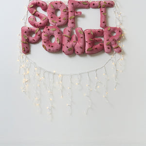 Kate Mitchell, Keeping Soft Power At The Forefront, 2025, velvet, silk, stuffing, thread, pins, dried rose buds, bay leaves, LED lights and spell-water, 60 x 120 x 5 cm (text) (lights variable)
