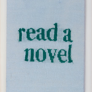 Kate Just, Read a Novel, 2023, from Self Care Action Series, hand knitted acrylic yarn, canvas, and timber, 55 x 40 cm 