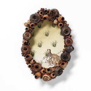 Sera Waters, Beyond Clearing/Beyond McCubbin (homage to Bruce Pascoe), 2022, found frame, gumnuts, cotton, leather, 36 x 26 cm