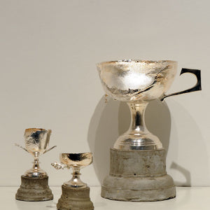 Elvis Richardson, The impossibility of losing in the mind of someone winning, 2008, cast concrete, found trophies burnt and resilvered, group of 3, dimensions variable