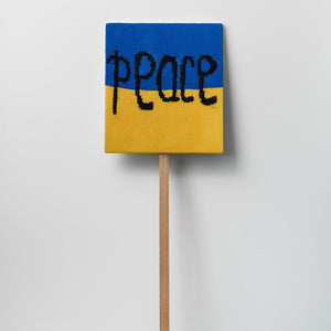 Kate Just, Peace, 2022, knitted wool as placard with plywood stand, 56 x 50 cm